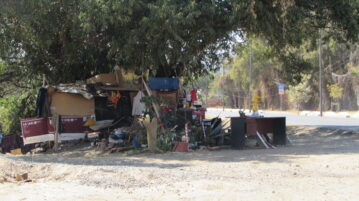 Unhoused persons set up dwellings on the Carretera