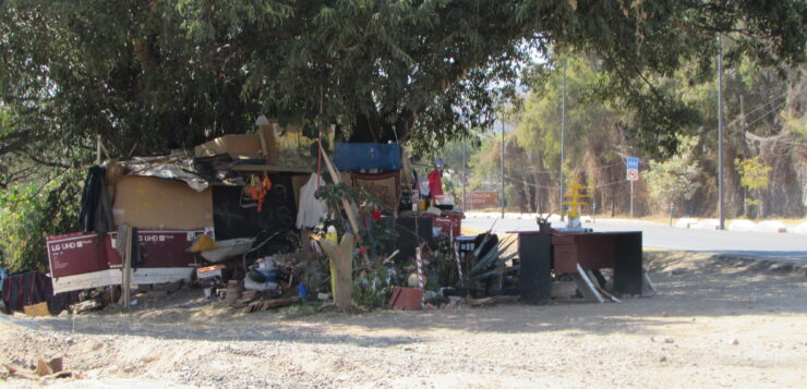 Unhoused persons set up dwellings on the Carretera